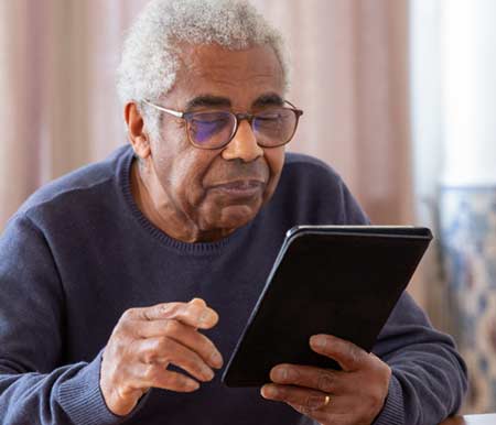 photo of a senior reading a tablet